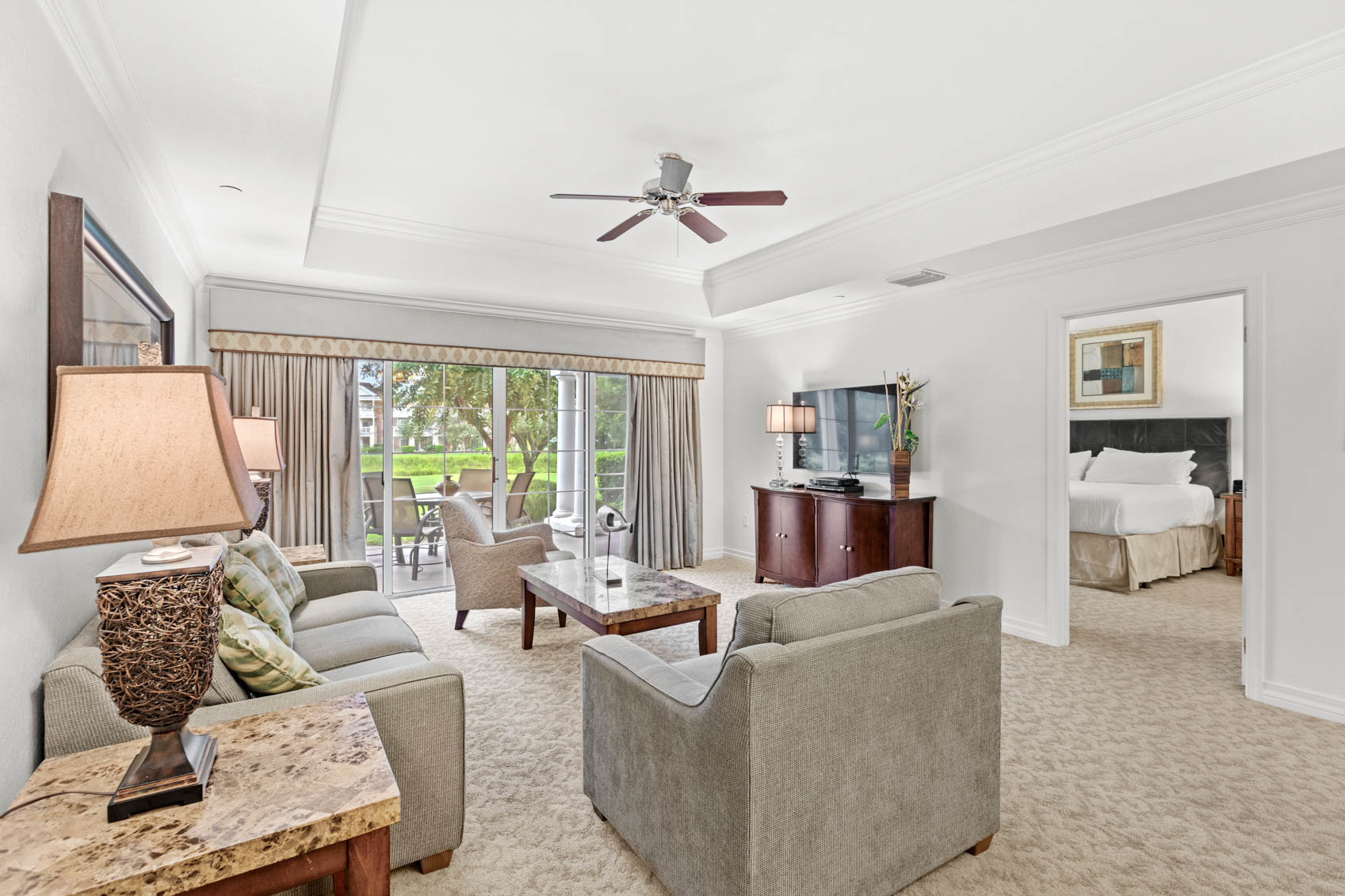 living room with grey couches and door to primary suite